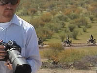 Periodista, detr�s, militares motorizados. (25kb)